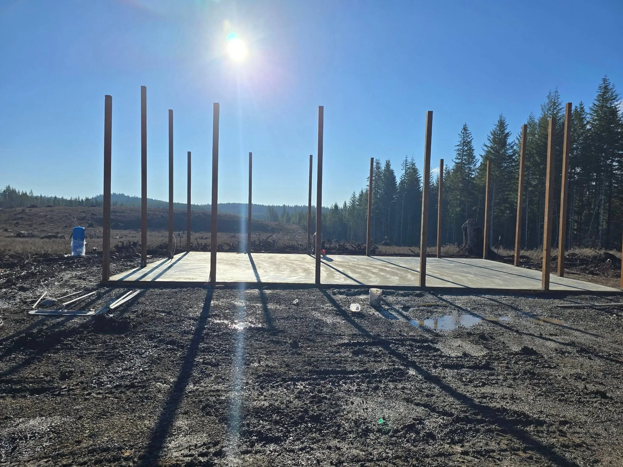 Concrete foundation pad with vertical steel posts installed on gravel base
