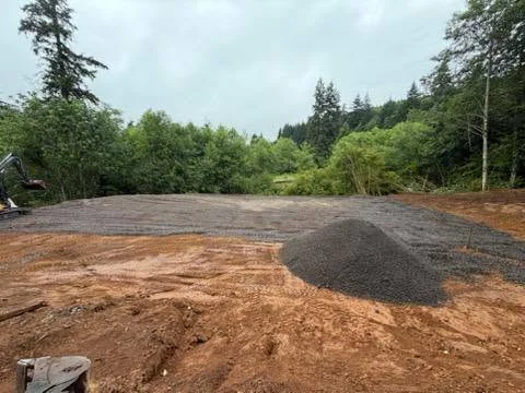 Driveway excavation with compacted gravel base and asphalt layer on prepared lot