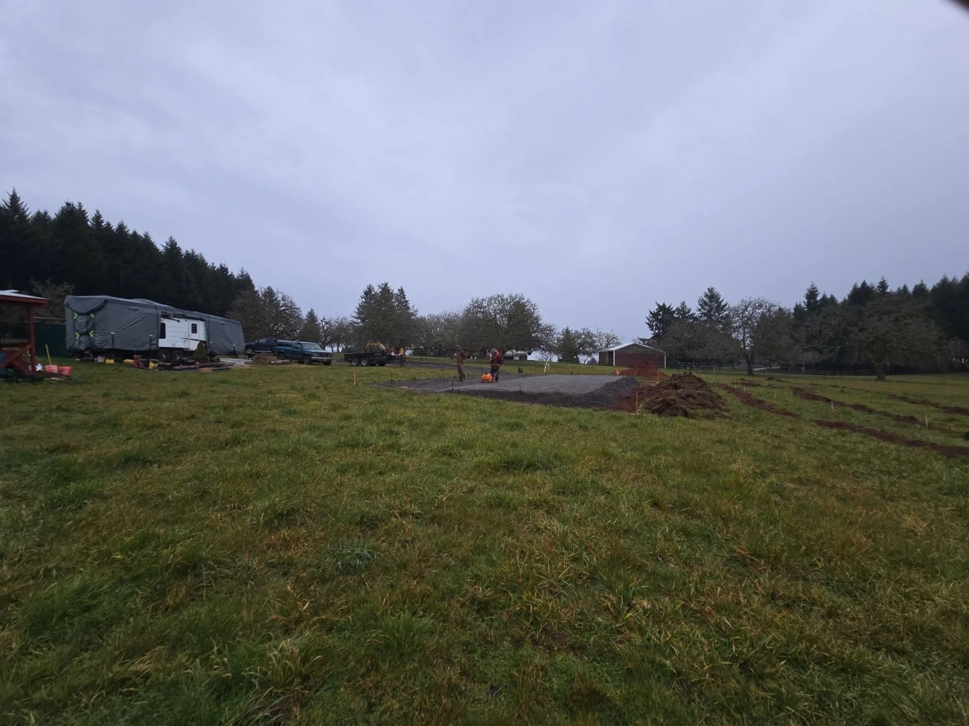 Excavated driveway site with graded soil, compacted base, and earthwork preparation on rural property